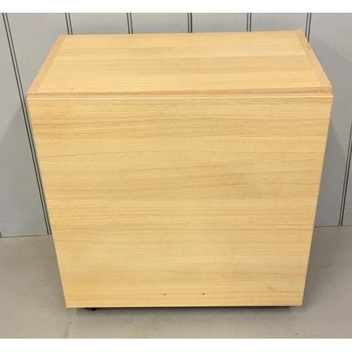 112 - A beech coloured, pedestal cupboard, on castors. Dimensions(cm) H63, W60, D37.