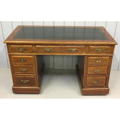 113 - A good quality, antique oak pedestal desk. Black leather writing top, with nine brass-handled drawer... 