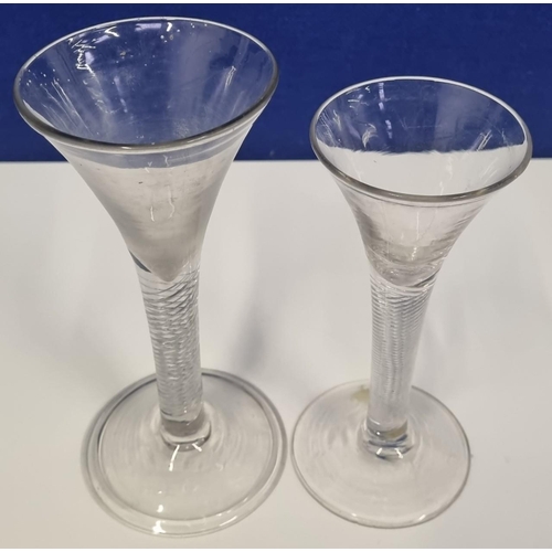 219 - Two similar, 18th century air twist stem, tapering wine glasses. Both with ground pontils. The large... 