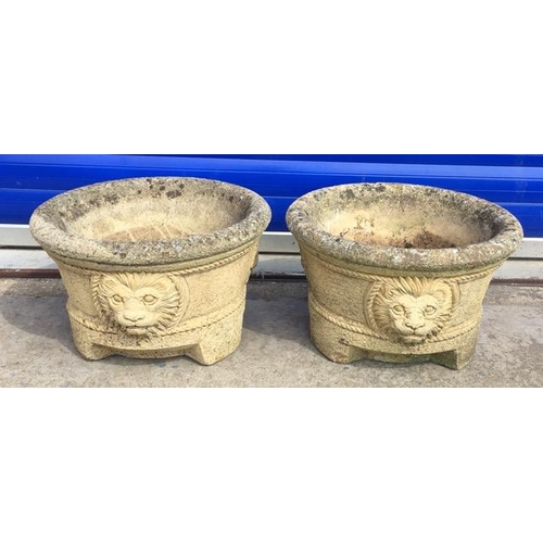 710 - A pair of stone planters, with Lion-head decoration. Height 23cm, diameter 37cm.