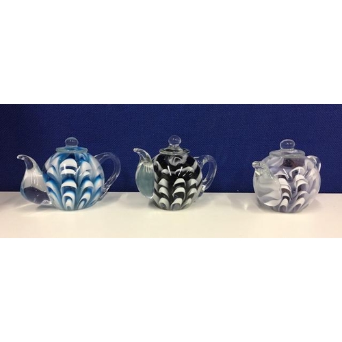 218C - A boxed set of three glass teapots.