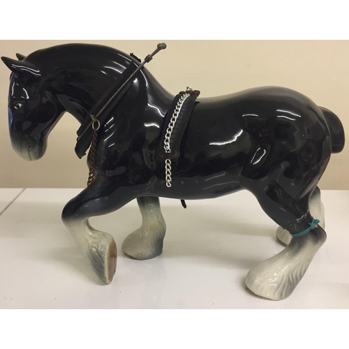 540 - A pair of ceramic shire horses. Black horse shows signs of repair.