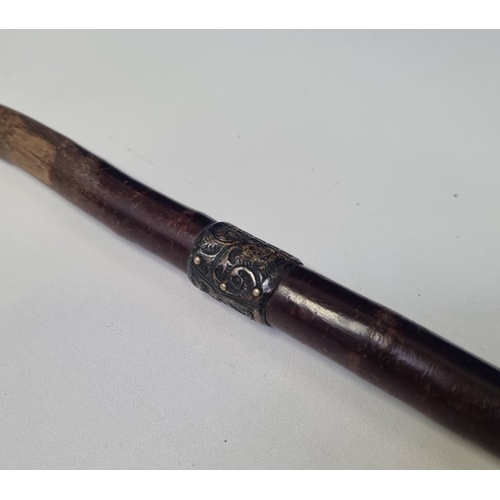 630C - A wooden walking cane, of some age with a likely silver, unmarked decorative band.