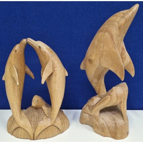 638 - Two nicely carved wooden dolphin ornaments. A family group & a duo. Tallest ornament height 35cm.