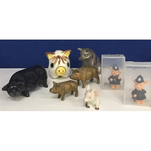 579 - A collection of pig figures. To include Bovey Pottery, Alfo, two resin police officer pigs, brass pi... 