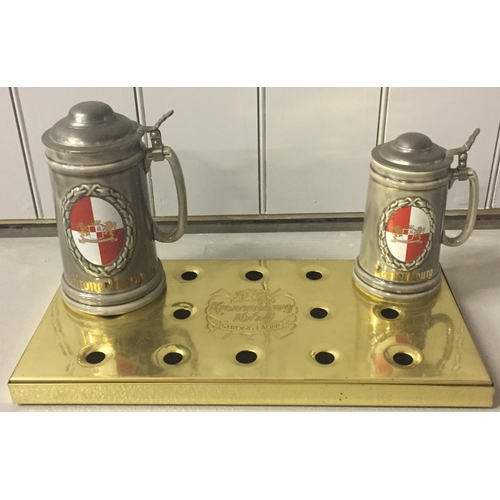 240 - A branded 'Kronenbourd' drip-tray, together with a pair of matching steins, by 'Wade'.