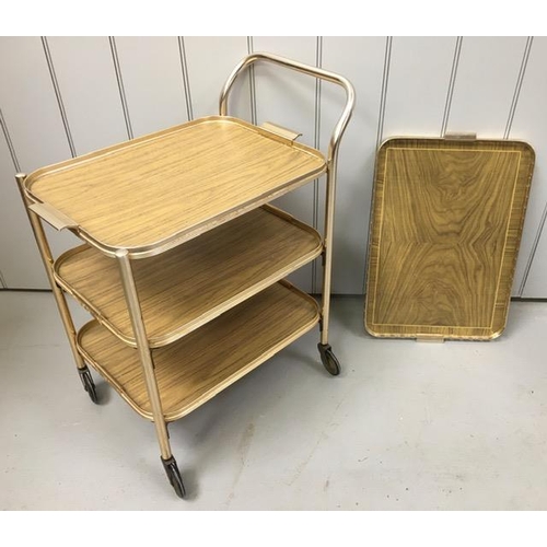 128 - A vintage, gold-coloured tea trolley, with three shelves, together with a similar-styled tray. Dimen... 