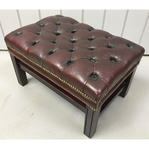 159 - A Chesterfield footstool, upholstered in oxblood-red leather. Dimensions(cm) H38, W65, D44.