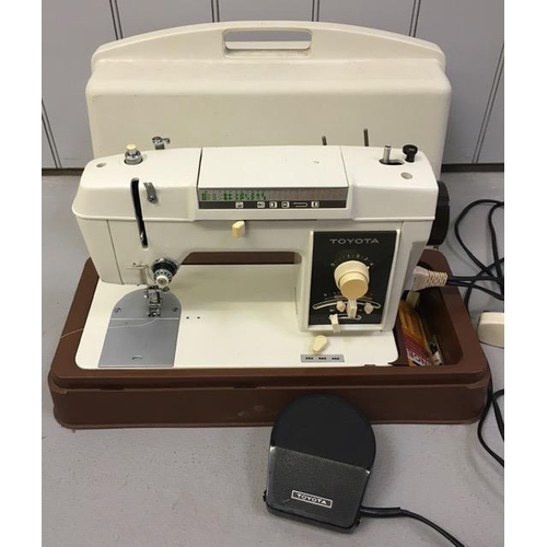 807 - A cased electric sewing machine, by 'Toyota'. Complete with foot pedal & accessories. PAT Test pass ... 