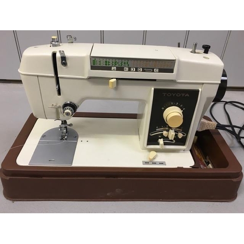 807 - A cased electric sewing machine, by 'Toyota'. Complete with foot pedal & accessories. PAT Test pass ... 