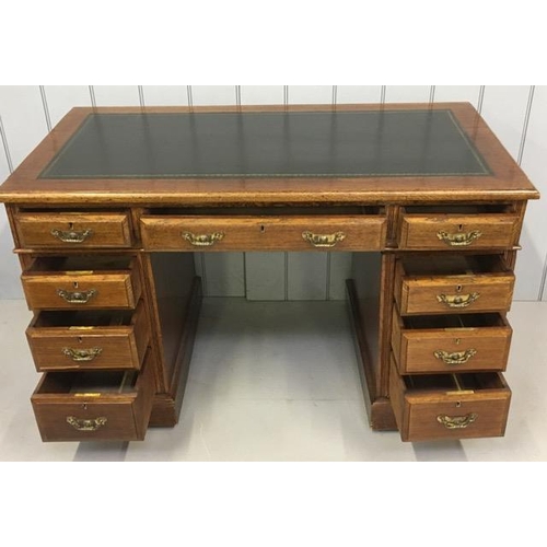 113 - A good quality, antique oak pedestal desk. Black leather writing top, with nine brass-handled drawer... 