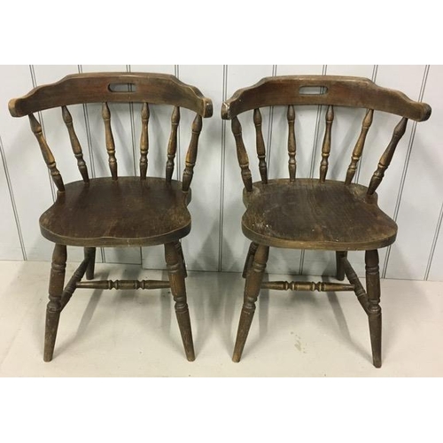 137 - A pair of early 20th century captain's chairs. Each features a pierced handle collar, on turned spin... 