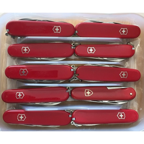 451 - A collection of ten red Swiss Army knives.