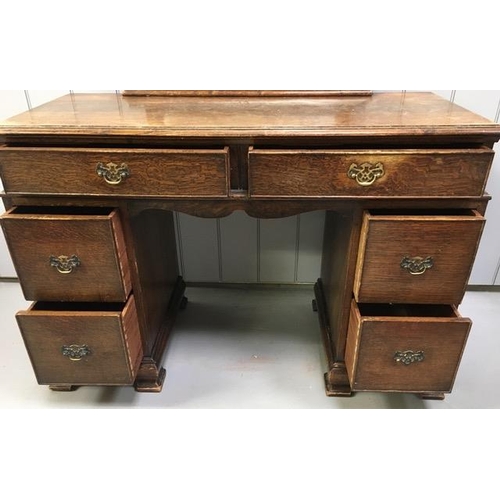 64 - An Edwardian oak dressing table. Two shallow & four deep drawers. Tilting mirror (mirror requires wi... 