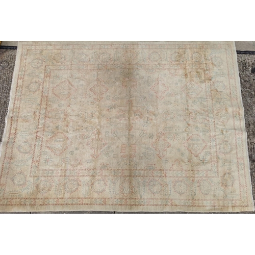 191 - A large, cream rug with Aztec-style pattern. Faded, with signs of wear. Dimensions 295cm x 217cm.