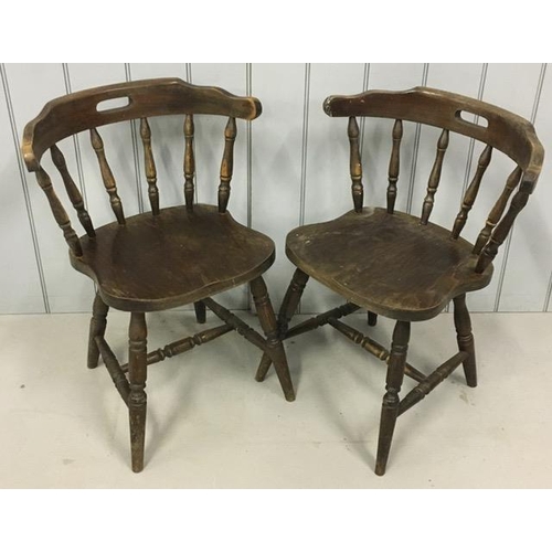 137 - A pair of early 20th century captain's chairs. Each features a pierced handle collar, on turned spin... 