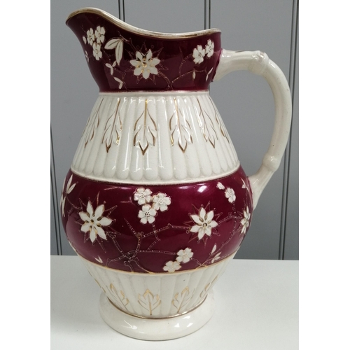 487 - A vintage maroon & white pitcher, nicely decorated with gold-coloured & floral detail. Height 33cm.