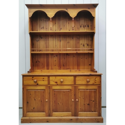 1003 - A solid pine Welsh dresser. Upper-level houses two plate-rack shelves, over a triple cupboard/drawer... 