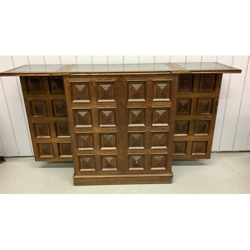 53 - A solid oak/panelled, metamorphic drinks bar. Features hinged opening glass holders & a hinged, exte... 