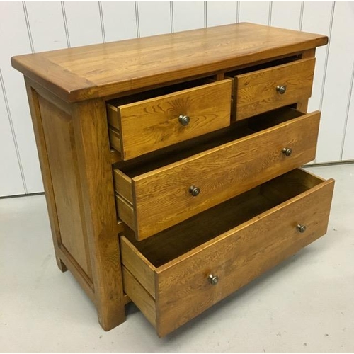 59 - A solid golden oak chest of two over two graduated drawers. Dimensions(cm) H83, W100, D44.