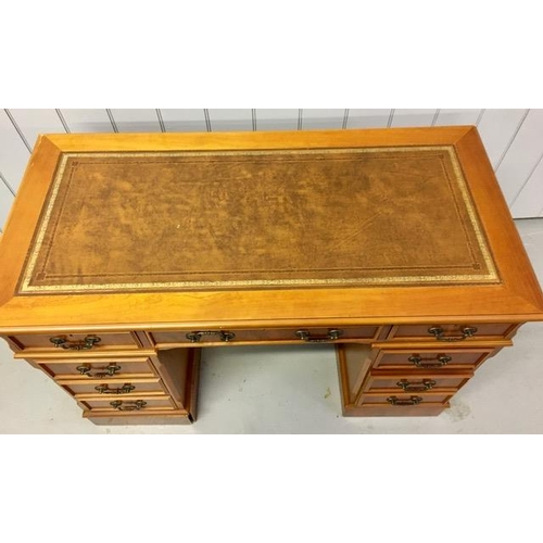 72 - A yew-veneered pedestal desk, with nine drawers. No key present. Left hand pedestal plinth will need... 