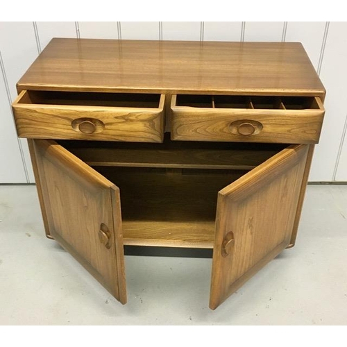 99 - An Ercol Windsor, dark elm sideboard/dining cabinet. Two drawers, over double cupboard. One drawer h... 