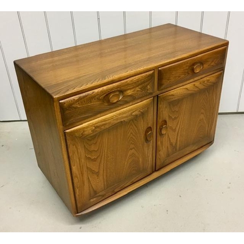 101 - An Ercol Windsor, dark elm sideboard/dining cabinet. Two drawers, over double cupboard. One drawer h... 