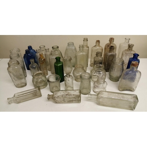 213 - A collection of thirty-five vintage medicine bottles, in clear, blue & green glass. To include two b... 