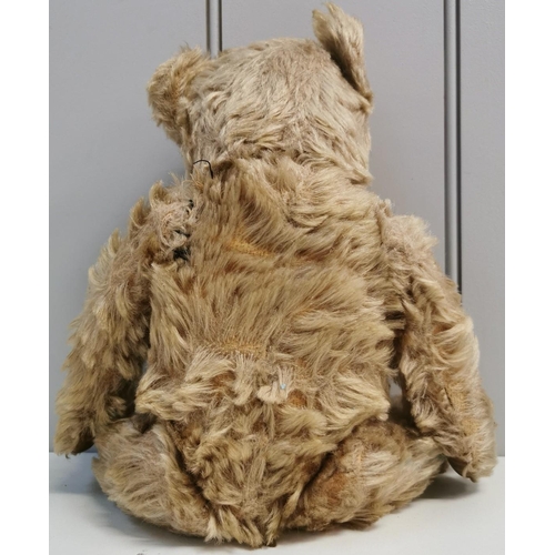 4086 - An early-mid 1900's, straw-filled teddy bear. Features include jointed limbs & squeaker(non-function... 