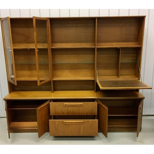 27 - A large teak display cabinet, by 'Meredew'. Base features two double cupboards aside twin drawers an... 