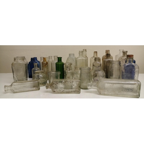 213 - A collection of thirty-five vintage medicine bottles, in clear, blue & green glass. To include two b... 