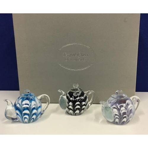 218C - A boxed set of three glass teapots.