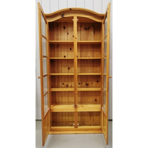 33 - A tall, solid pine glazed bookcase, with five shelves and a cupboard space to base. Dimensions(cm) H... 