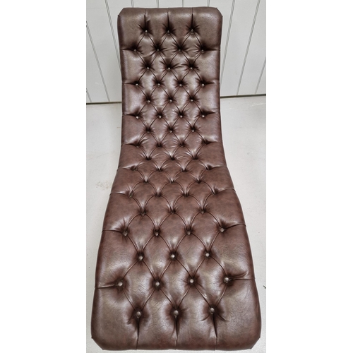 120 - A stylish, contemporary chaise longue. Upholstered in brown buttoned leather, supported by a gold-co... 