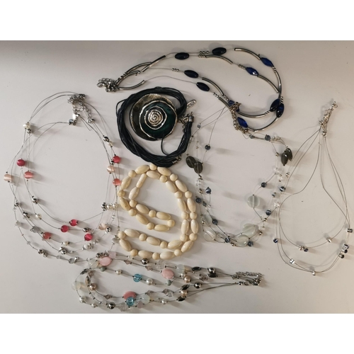 857 - A selection of seven pieces of costume jewellery. To include wire & beaded necklaces & a power shell... 