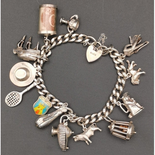 871 - A silver charm bracelet, with thirteen  charms (five clearly marked as silver). Charms include a cas... 