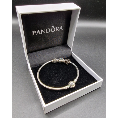 875 - A silver 'Pandora' charm bracelet, with three charms, together with a pair of white metal bangles.