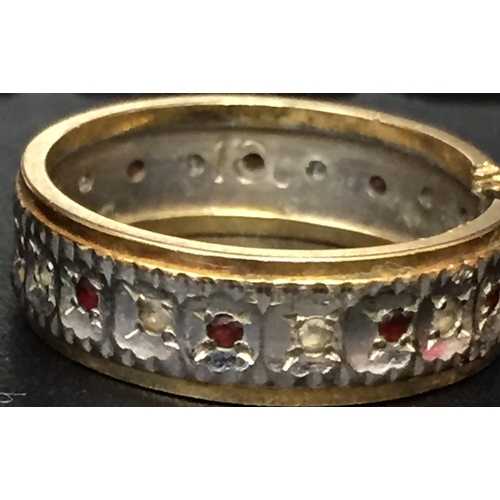 890 - A yellow metal ring (acid tests as 18ct Gold) decorated with a circle of small diamonds & rubies. Ri... 