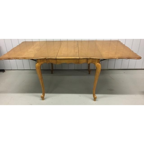 18 - A drop leaf extendable dining table, with a scalloped edge. Multi-extendable, complete with two addi... 