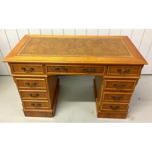 72 - A yew-veneered pedestal desk, with nine drawers. No key present. Left hand pedestal plinth will need... 