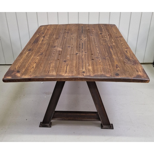 91 - An industrial-styled dining table. Rustic plank-topped, with weathered steel trestle supports. Dimen... 