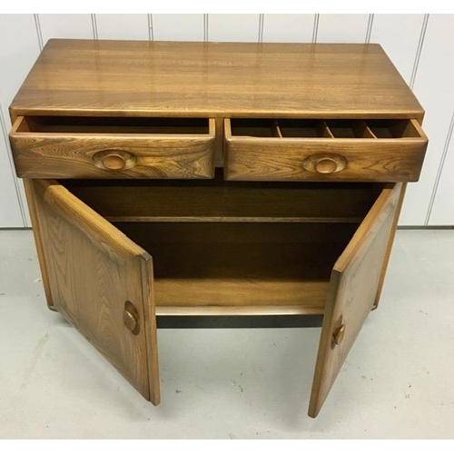 101 - An Ercol Windsor, dark elm sideboard/dining cabinet. Two drawers, over double cupboard. One drawer h... 