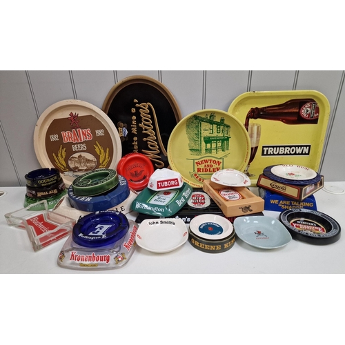 173 - A large collection of branded pub trays & ashtrays, together with a drip tray.