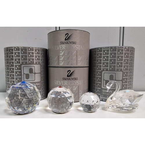 217 - A collection of four boxed pieces of 'Swarovski' crystal art. To include a Swan & three graduated cr... 