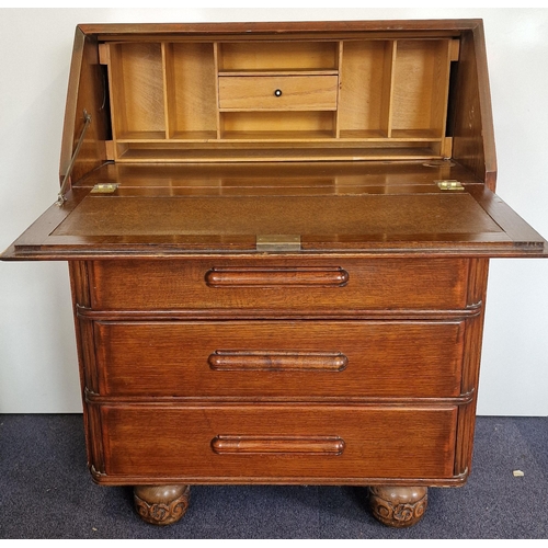 14 - An Edwardian period, oak bureau. Drop-front, partially fitted interior over three graduated drawers.... 