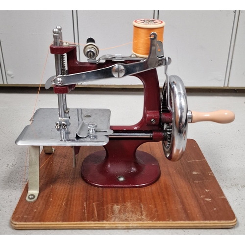 1429 - A vintage, miniature table top travel sewing machine, with an original carry case.