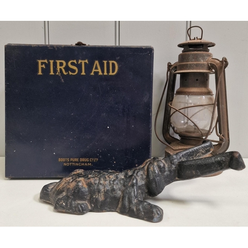 1433 - A mixed lot. To include a vintage 'Boots' first aid kit, storm lantern & iron doorstop.