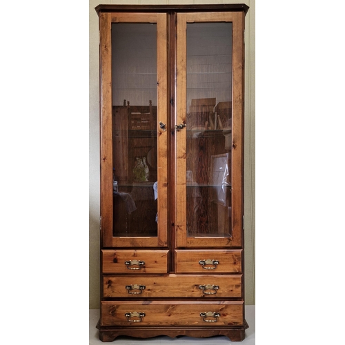 25 - A good quality, dark stained pine display cabinet, with three internal glass shelves & brass fitting... 