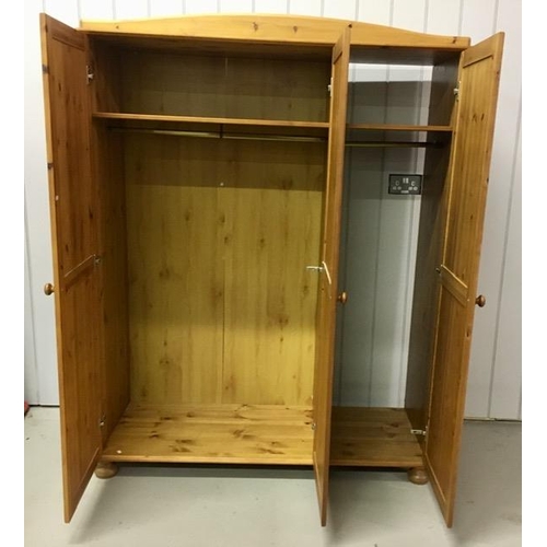 37 - A pine triple wardrobe. Incorporates double & single hanging rails, single shelf throughout & is sup... 