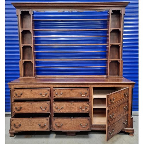 50 - A substantial Georgian open dresser. Plate shelves flanked by display compartments, over a triple dr... 
